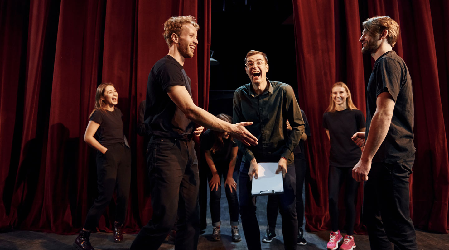 Groupe d'adultes débutants faisant un exercice d'improvisation dans un cours de théâtre parisien, atmosphère bienveillante et décontractée